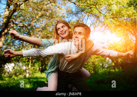 Portrait of happy couple raising their hands in open air. Stock Photo