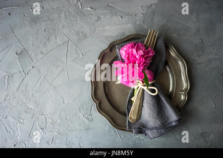 Summer table setting with bright peonies on dark rustic table with copyspace Stock Photo