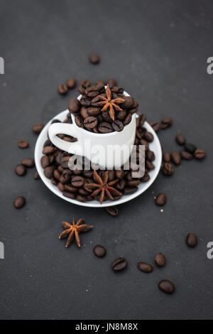 Coffee mug full of organic coffee beans on dark background with copyspace Stock Photo