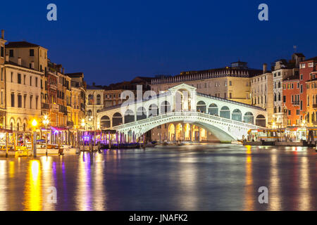 Venice,  Veneto, Italy view of the Rialto Bridge during blue hour with reflections on the water and illuminated pilazzos. Long exposure view with moti Stock Photo