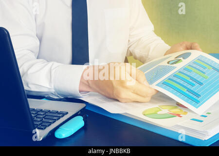 Manager analyzing financial graphs on office table. Stock Photo