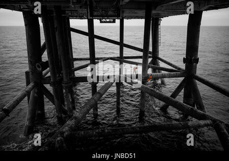 A selective colour image or two industrial rope access technician, stood on an oil and gas rig bracing. credit: LEE RAMSDEN / ALAMY Stock Photo