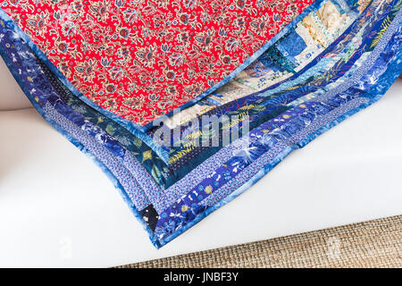 quilting, interior, culture, hobby, passion, handcraft concept - bright multicolored blanket is decorated with various flowers, leaves, dragonflies an Stock Photo