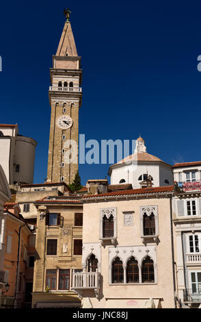 Bell and clock tower of St George's Parish Catholic Cathedral and baptistery with pink Venetian House in Tartini Square Piran Slovenia Stock Photo