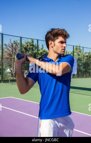 Professional tennis player is doing a kick tennis on a tennis court on a sunny summer morning. The is dressed in sportswear. Stock Photo