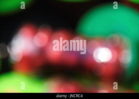 Blurred image, bright red spots against green and black background Stock Photo