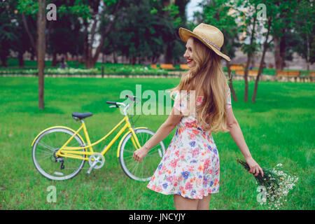 Beautiful happy young woman enjoying summer with wild-flower bunch Stock Photo