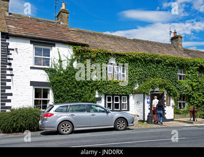 Couple walking into the Street Head Inn, Newbiggin, Bishopdale, Yorkshire Dales National Park, North Yorkshire, England UK Stock Photo