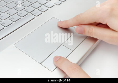 Human fingers working on laptop touchpad Stock Photo