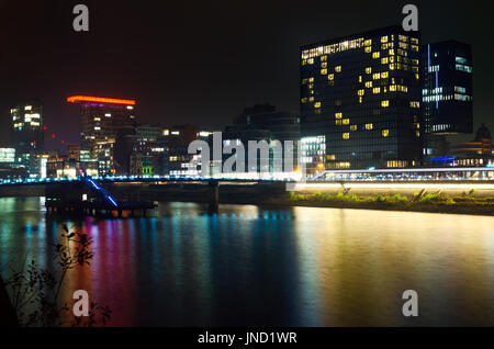 Night cityscape of bay in Dusseldorf with reflection at Rhine river; Urban night scene with hotel, restaurants and office buildings Stock Photo