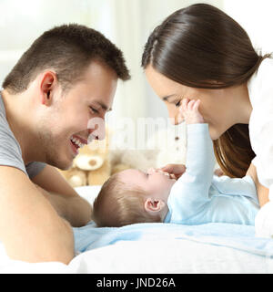 Side view close up of a baby playing with his parents on a bed Stock Photo