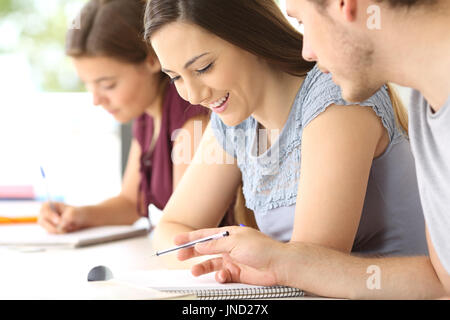 Tho happy students talking about class work at classroom Stock Photo