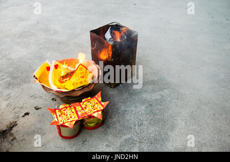 People burn joss paper gold and silver paper for worship with paper made to resemble money and burned as sacrificial offering for pray to god and memo Stock Photo