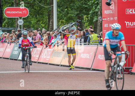 London, UK. 30th July, 2017. A riders bike fails just before he crosses the finish line so he has to carry it the last few metres - the Prudential Ride London Surrey 100 finishes in the Mall. Credit: Guy Bell/Alamy Live News Stock Photo