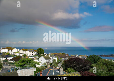 Mousehole, Cornwall, UK. 30th July 2017. UK Weather. After a sunny afternoon a sudden deluge brought a rainbow over Mousehole and the sea at Mounts Bay Credit: Simon Maycock/Alamy Live News Stock Photo