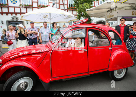 Wettenberg, Germany. 29th July, 2017. Frl. Menke meets a model of her first own car - a Citroën 2CV - at Golden Oldies Festival in Wettenberg, Germany. Frl. Menke (born November 4, 1960 as Franziska Menke in Hamburg, Germany) was a star of the Neue Deutsche Welle genre of German popular music in the early 1980s. The Golden Oldies Festival is a annual nostalgic festival (est. in 1989) with focus on 1950s to1970s, over 1000 exhibited classic cars and old-timers, over 50 live bands. - Credit: Christian Lademann Stock Photo