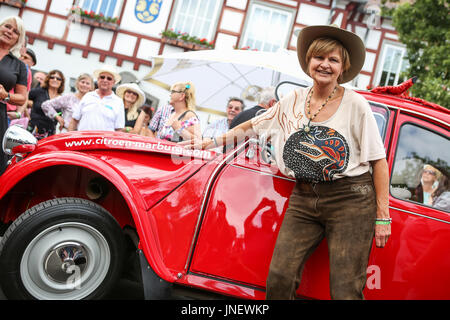 Wettenberg, Germany. 29th July, 2017. Frl. Menke meets a model of her first own car - a Citroën 2CV - at Golden Oldies Festival in Wettenberg, Germany. Frl. Menke (born November 4, 1960 as Franziska Menke in Hamburg, Germany) was a star of the Neue Deutsche Welle genre of German popular music in the early 1980s. The Golden Oldies Festival is a annual nostalgic festival (est. in 1989) with focus on 1950s to1970s, over 1000 exhibited classic cars and old-timers, over 50 live bands. - Credit: Christian Lademann Stock Photo