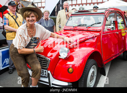 Wettenberg, Germany. 29th July, 2017. Frl. Menke meets a model of her first own car - a Citroën 2CV - at Golden Oldies Festival in Wettenberg, Germany. Frl. Menke (born November 4, 1960 as Franziska Menke in Hamburg, Germany) was a star of the Neue Deutsche Welle genre of German popular music in the early 1980s. The Golden Oldies Festival is a annual nostalgic festival (est. in 1989) with focus on 1950s to1970s, over 1000 exhibited classic cars and old-timers, over 50 live bands. - Credit: Christian Lademann Stock Photo