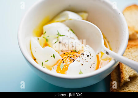 Soft boiled eggs with salt, pepper thyme and rusk bread Stock Photo