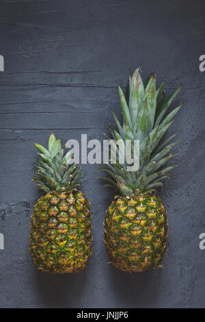 Two pineapples on dark concrete background, top view Stock Photo
