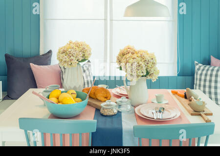 Wooden table and chair in vintage dinning room at home. Table set on dining table, interior design. Stock Photo