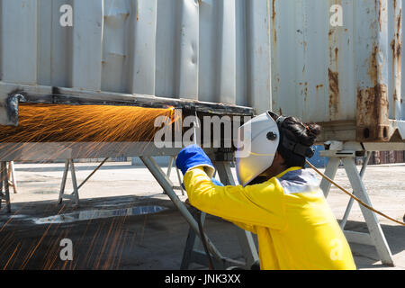 Industry worker with protective mask welding steel to repair container structures manufacture workshop. Worker welding in factory industry. Stock Photo