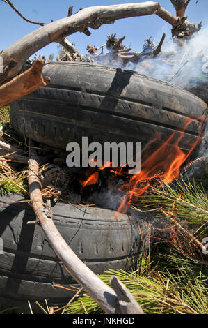 How to start a fire with old tires and branches. a set of 5 images Stock Photo