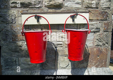 Two old battered red fire buckets side by side Stock Photo