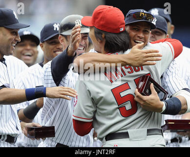 2009 World Series MVP Hideki Matsui, center, who wore the number 55 as a  member of the New York Yankees, is flanked by his father Masao, left, and  mother Saeko, as he