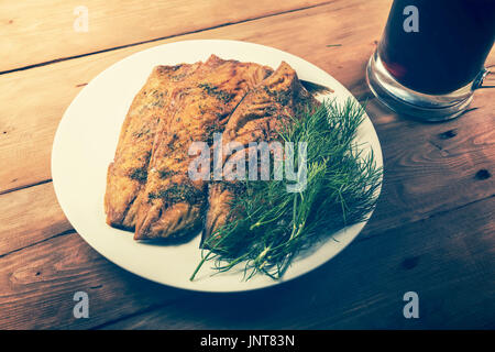 smoked mackerel fish fillet with herbs on white dish Stock Photo