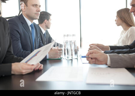 Business people discussing documents at workplace in office sitting around the table Stock Photo