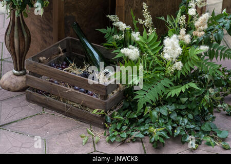 Wedding decorations with flowers, wooden box and wine bottles.. Rustic style. Stock Photo
