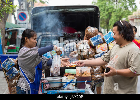 Bangkok, Thailand - February 17, 2015: woman selling cooked food from stand in the street Rattanakosin, Bangkok Old City Stock Photo