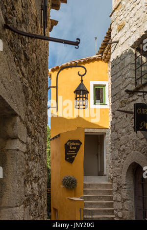 Eze, Alpes-Maritimes, France - October 11, 2015: Street in Eze with artist's studio sign. Eze is a quaint, well-preserved, old village on the Mediterranean in the Alpes-Maritimes department of France, popular with tourists. Stock Photo
