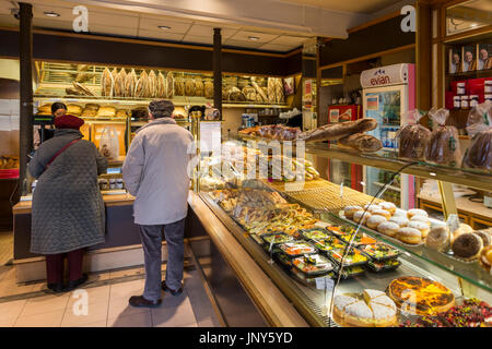 Paris, France - February 29, 2016: Older man and woman shopping in a bakery and pastry shop in the Marais, Paris. Stock Photo