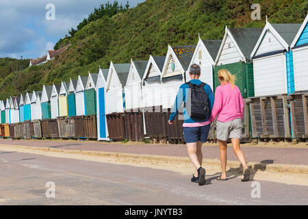 Bournemouth, Dorset, UK. 31st July, 2017. UK weather: after a weekend of mixed weather, a warm sunny start to the new week, as visitors head to the seaside to make the most of the sunshine. Couple walking along promenade past beach huts at Middle Chine. Credit: Carolyn Jenkins/Alamy Live News Stock Photo