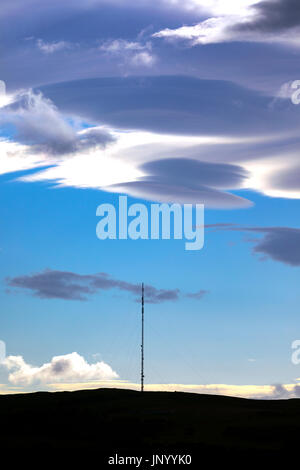Strange clouds known as Lenticular Clouds appearing over the Moel-y-Parc mast on the Clwydian Range hills, Wales Stock Photo