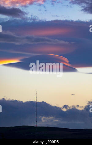 Strange clouds known as Lenticular Clouds appearing over the Moel-y-Parc mast on the Clwydian Range hills, Wales Stock Photo