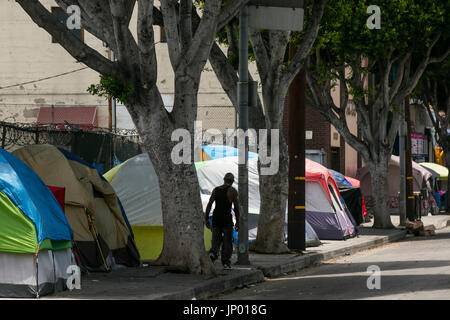 Los Angeles, California, USA. 27th July, 2017. A homeless man walks past tents on San Pedro St in the Skid Row area of Los Angeles. Credit: Jonathan Alcorn/ZUMA Wire/Alamy Live News Stock Photo