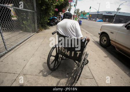 Los Angeles, California, USA. 27th July, 2017. A homeless man sits in a wheelchair on a sidewalk in the Skid Row area of Los Angeles. Credit: Jonathan Alcorn/ZUMA Wire/Alamy Live News Stock Photo