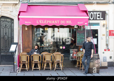 Paris, France - March 2, 2016: Waiter and customer smoking outside L'elephant du Nil restaurant on rue de Rivoli in the Marais, Paris, France. Stock Photo
