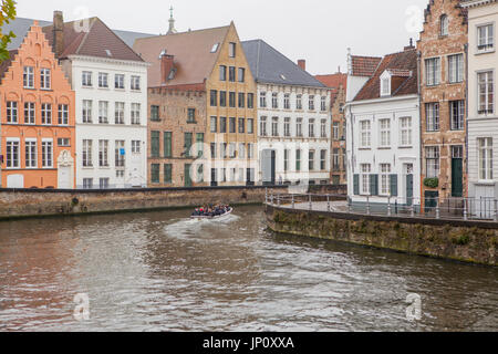 Bruges, Belgium – October 31, 2010: Tour boat on the canal in the old part of Bruges, Belgium. Stock Photo