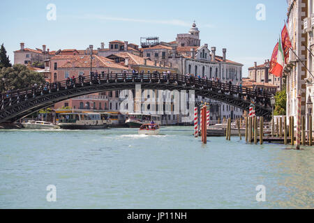 Venice, Italy - April 26, 2012: The Accademia bridge over the Grand Canal in Venice. Two vaporettos and some water taxis are on the Grand Canal.