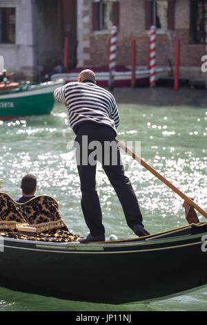 Venice, Italy - April 26, 2012: Gondola and gondoLier on the Grand Canal, Venice. Stock Photo