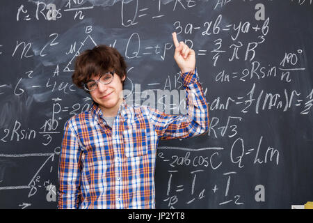 Boy and blackboard filled with math formulas Stock Photo