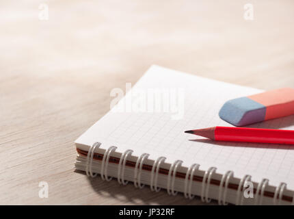 Pencil and eraser on blank spiral notebook on desk. Place for your text Stock Photo