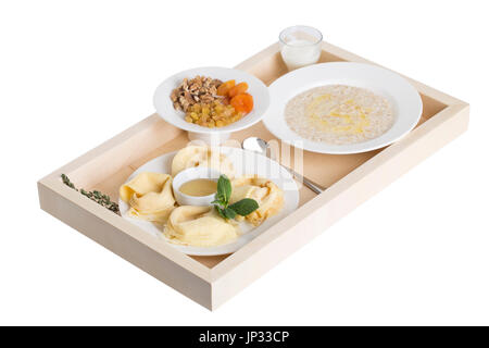 Russian pancakes with oatmeal and dried fruits on a wooden tray. Isolated on a white background. Stock Photo