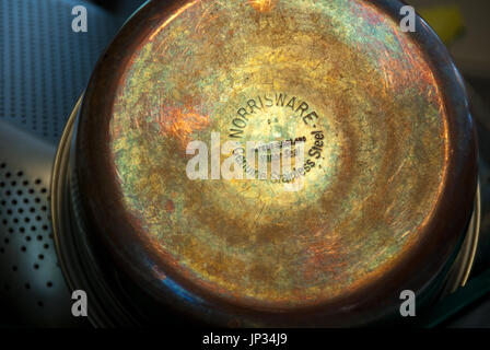 Reflecting light reveals the beautifully colored patina of copper bottom cookware. Stock Photo