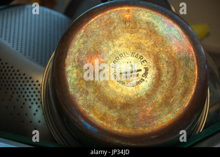 Reflecting light reveals the beautifully colored patina of copper bottom cookware. Stock Photo