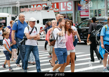 People are crossing an avenue during the day in Manhattan. Stock Photo